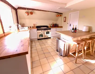 a kitchen with a counter and a stove top oven at Secluded 16th Century Farmhouse with private grounds in Hatfield Peverel