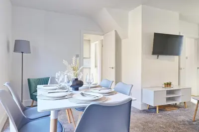 a white dining room with a white table and chairs at 3 Bed, Sleeps 6, Wifi, Free Parking in Writtle