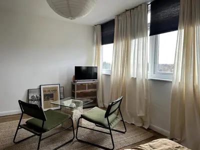a living room with two chairs and a table and a television at Flat-on-Sea in Southend-on-Sea