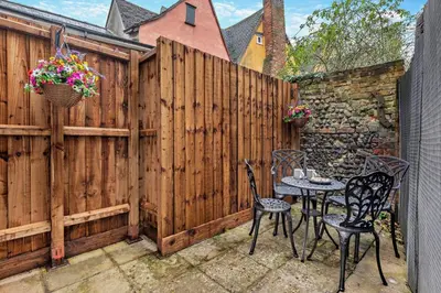 a patio with two chairs and a table next to a fence at 2 Bed in Lavenham oc-f30054 in Lavenham
