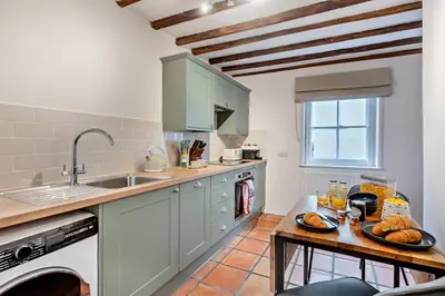 a kitchen with green cabinets and a table with bread on it at 2 Bed in Lavenham oc-f30054 in Lavenham