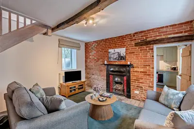 a living room with two couches and a brick wall at 2 Bed in Lavenham oc-f30054 in Lavenham