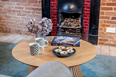 a table with a plate of donuts and a book at 2 Bed in Lavenham oc-f30054 in Lavenham