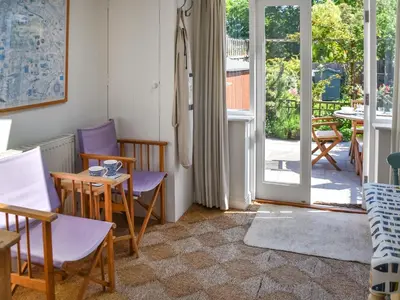a living room with a table and chairs and a sliding glass door at Eva's Cottage in Wenhaston