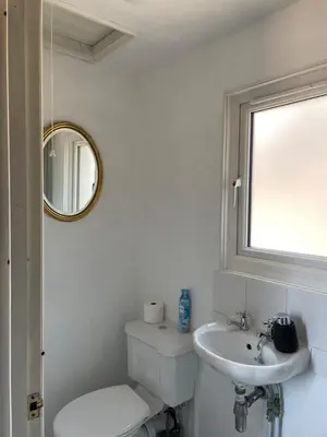 a white bathroom with a toilet and a sink at Barn conversion Corner Annexe in Earls Colne