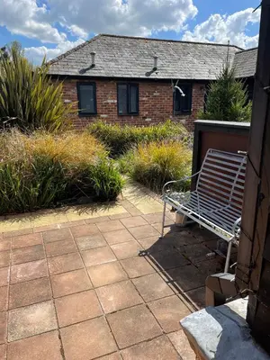 a bench sitting in front of a brick house at Barn conversion Corner Annexe in Earls Colne