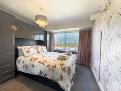 a bedroom with a bed and a large window at Basildon Retreat Cozy 3-Bedroom Home in Basildon