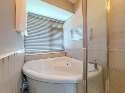 a bathroom with a toilet and a sink and a shower at Basildon Retreat Cozy 3-Bedroom Home in Basildon