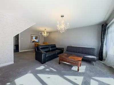a living room with a black couch and a coffee table at Basildon Retreat Cozy 3-Bedroom Home in Basildon