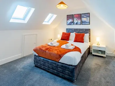 a bedroom with a large bed and skylights at Hawkwell Retreat 5 Bedroom home Hockley - Pass the Keys in Hawkwell
