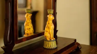 a wooden cat statue sitting on a table in front of a mirror at Paradise Penthouse in Downham Market
