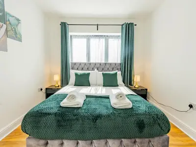 a bedroom with a large bed with two towels at Hawkwell Hideaway Large 4 bedroom Home Hockley - Pass the Keys in Hawkwell