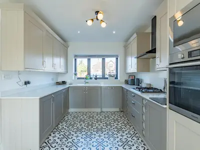 a kitchen with white cabinets and a tile floor at Hawkwell Hideaway Large 4 bedroom Home Hockley - Pass the Keys in Hawkwell