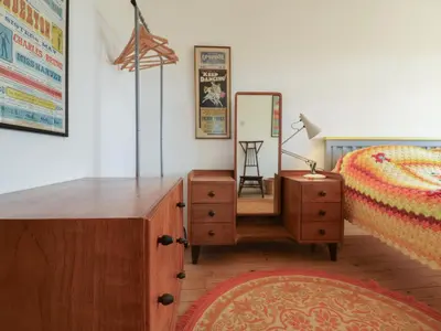 a bedroom with a bed and a dresser and a mirror at The Orchard Close Art House in Great Livermere