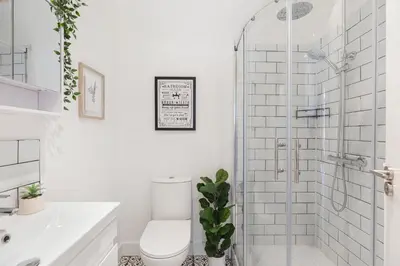 a bathroom with a toilet and a glass shower at Chandini Villa in High Wych in Sawbridgeworth