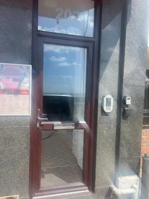a glass door with a television inside of it at Ocean Breeze in Thorpe Bay