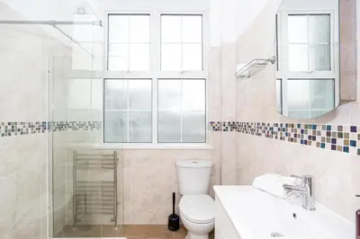a bathroom with a toilet and a shower and a sink at Ocean Breeze in Thorpe Bay