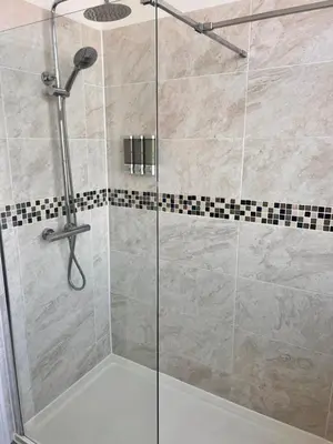 a shower with a glass door in a bathroom at Ocean Breeze in Thorpe Bay