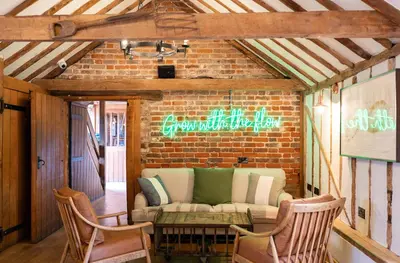 a living room with a couch and a brick wall at Tewinbury Farm Hotel in Tewin