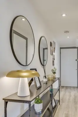 a mirror on a wall next to a table with a mirror at Stylish stay Ware town with parking in Ware