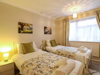a bedroom with two beds and a window at Crown Farm in Wisbech