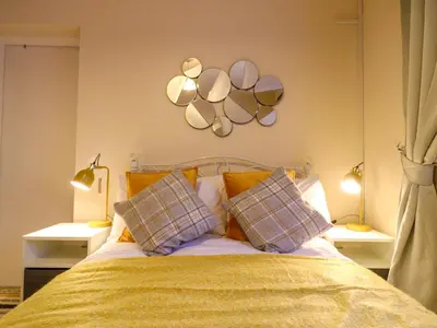 a bedroom with a bed with two mirrors on the wall at Crown Farm in Wisbech