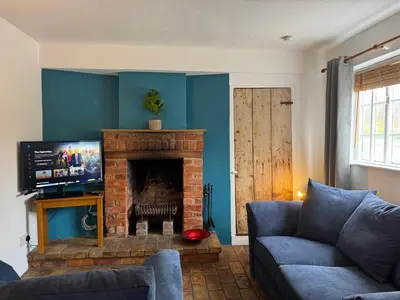 a living room with a couch and a fireplace at Cosy Little Cottage in Woodbridge