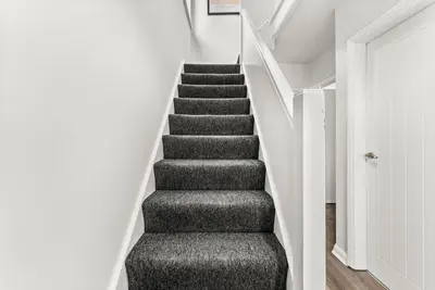 a staircase in a house with a gray carpet at Gorgeous Abode in Cambridge - Pet Friendly! in Cherry Hinton