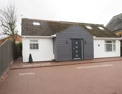 a grey and white house with a black door at The Nest in Needingworth