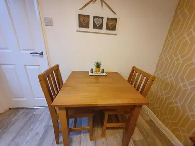 a dining room table with two chairs and a plant on it at The Nest in Needingworth