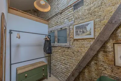 a room with a brick wall and a refrigerator at The Stables in Southend-on-Sea