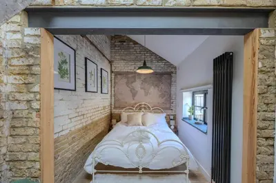 a bed in a room with a brick wall at The Stables in Southend-on-Sea