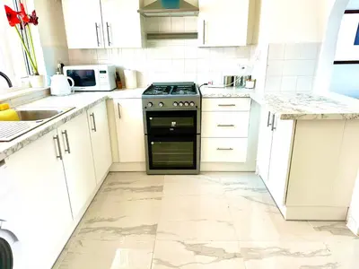 a kitchen with white cabinets and a black oven at Modern Stylish 4Bed 2 Bath in Pitsea, Basildon Essex 2 Free Carpark in Nevendon