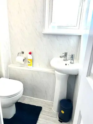 a white bathroom with a toilet and a sink at Modern Stylish 4Bed 2 Bath in Pitsea, Basildon Essex 2 Free Carpark in Nevendon