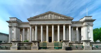 a large white building with columns on a street at Stylish 3-Bedroom Detached Home in Cambridge in Chesterton