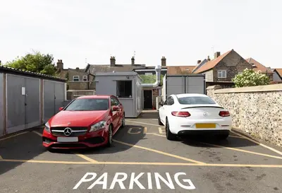 two cars are parked in a parking lot at Brandon Apartment in Town Centre with parking in Brandon