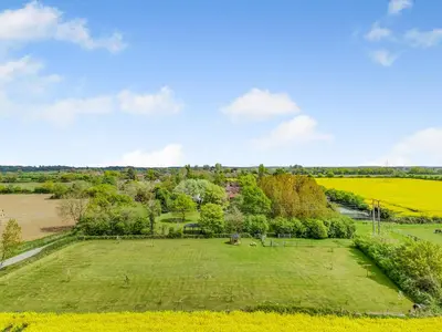 an aerial view of a large grassy field with trees at Cedar - Uk49525 in Saint Lawrence