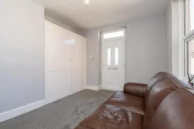 a living room with a leather couch and a window at The Harwich Hideaway in Harwich