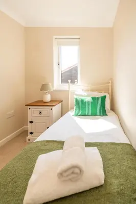 a bedroom with two beds with towels on them at 3 St Johns Court - Aldeburgh Coastal Cottages in Aldeburgh