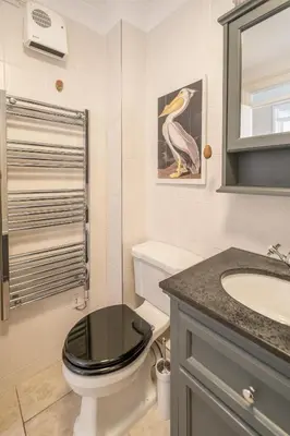 a bathroom with a black toilet and a sink at 3 St Johns Court - Aldeburgh Coastal Cottages in Aldeburgh