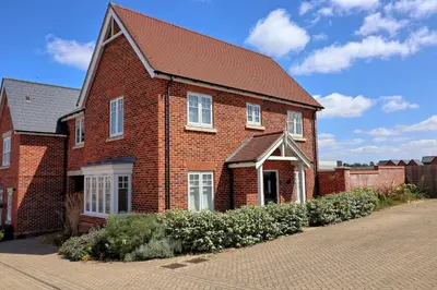 a brick house with a brown roof on a street at Spacious Colchester Home with Off-Street Parking for 4 cars in Colchester