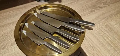 a gold plate with four knives on a table at Spacious Colchester Home with Off-Street Parking for 4 cars in Colchester