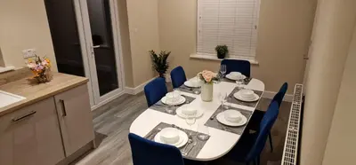 a dining room with a table and blue chairs at Spacious Colchester Home with Off-Street Parking for 4 cars in Colchester