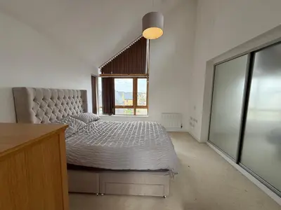 a bedroom with a bed and a large window at Spacious 4 Bedroom Townhouse in Essex in Burnt Mill