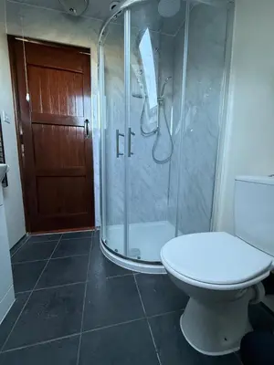 a bathroom with a toilet and a glass shower at The Lodge in Prickwillow