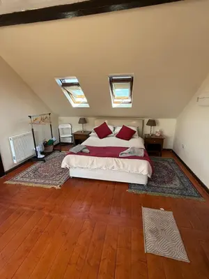 a bedroom with a large bed with red pillows at The Lodge in Prickwillow