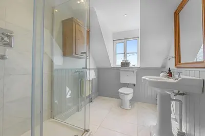 a bathroom with a shower and a sink and a toilet at Bakers Cottage, Blackmore End in Gosfield