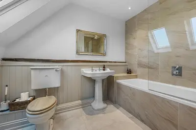 a bathroom with a toilet and a sink and a bath tub at Bakers Cottage, Blackmore End in Gosfield
