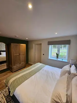 a large bedroom with a large bed with a window at Russet Suite - The Apple Barn in Pettistree