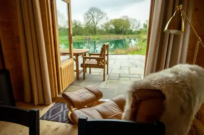 a living room with a couch and a large window at Welhams Meadow Holiday Lodges in Ringshall